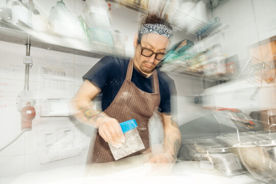 Baker preparing dough with motion blur in bakery