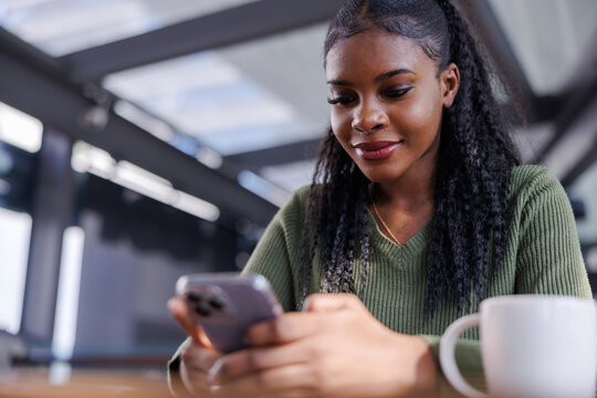Woman texting back friend at a cafe