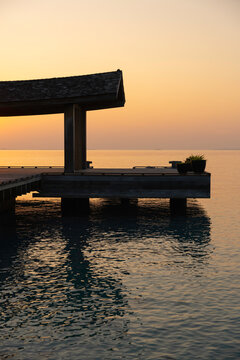 Warm sunrise over the ocean through a timber pier structure