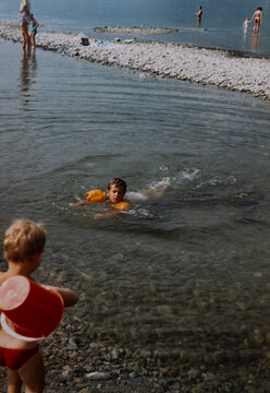 Child swimming with inflatable armbands