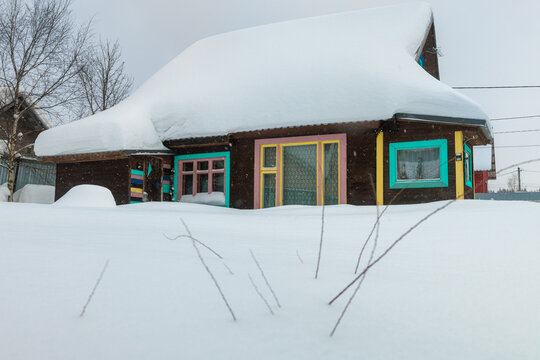 Snow Covers a Colorful House in Winter Landscape