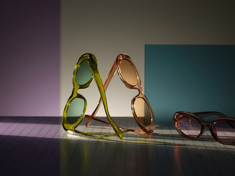 Stylish sunglasses in vibrant colors arranged artfully on geometric