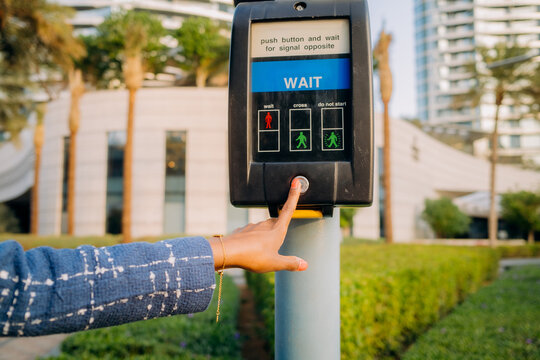 The woman presses the button to call the traffic light