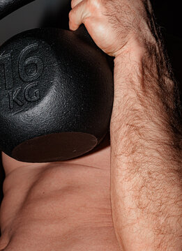 Lifting a 16 Kg Kettlebell During a Workout Session