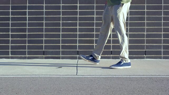 Unsuspecting man finds lost USB thumb drive on ground illustrating malicious USB drop attack - Cybersecurity Information Technology Concept