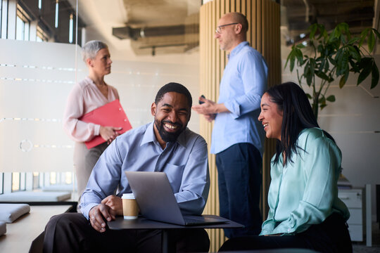 Colleagues discuss business at lounge area