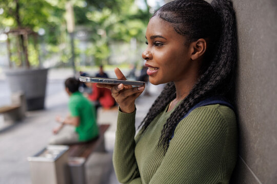 Woman talking over speakerphone outside