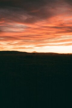 colorful pink cloudy sunset sky over mountain top landscape field film