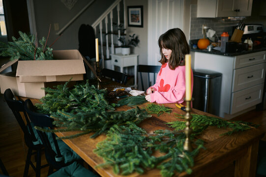 little girl getting ready to make a wreath in her kitchen dining area