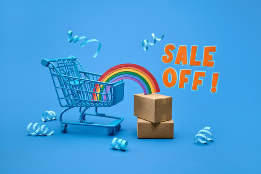 Blue shopping cart with rainbow and boxes, celebrating a sale