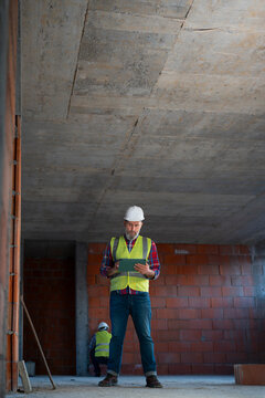 Construction worker checks plans on site