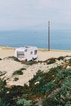 Camper van parked by the sea on a quiet coastal road
