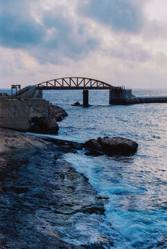 Coastal bridge over rough sea at dusk