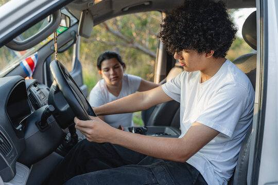 Mother teaching son driving lesson in car