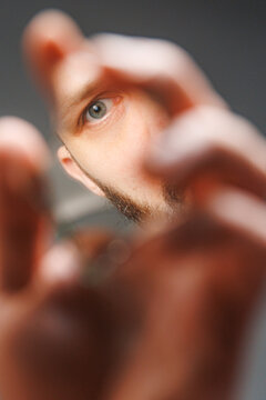 Person Looking Through a Mirror Object