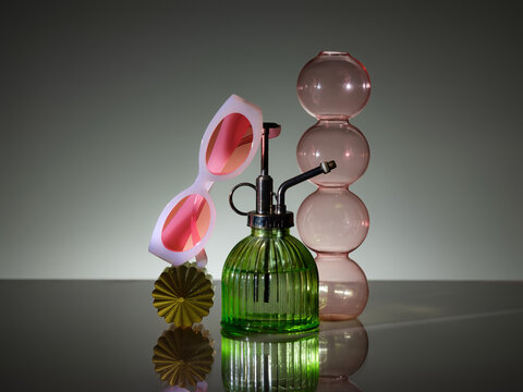 Retro-inspired still life with pink sunglasses and pink glass