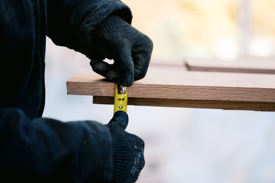 man measuring and sawing oak wood boards for diy project