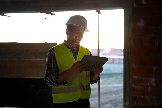 Worker with tablet on site at sunset