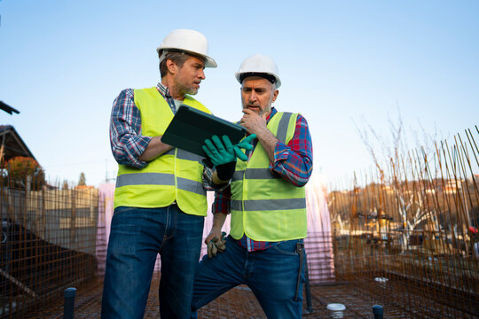 Workers discuss project outdoors