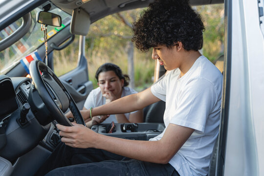 Teenage boy learning to drive with instructor