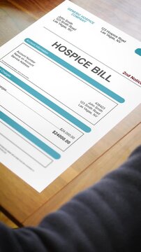 A Stressed Adult Looks at a Hospice Bill - Vertical