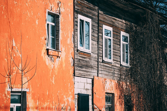 Old building with peeling paint and wooden structure in sunlight