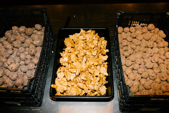 Plastic containers filled with fresh organic potatoes and mushrooms
