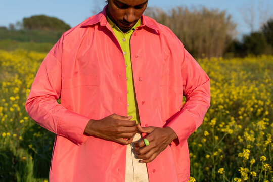 Man Buttoning Shirt Field