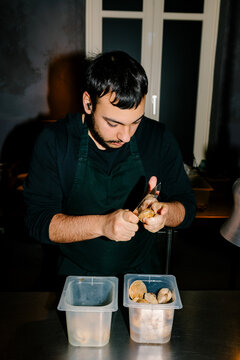 Professional chef shucking clams in a Canarian cuisine restaurant
