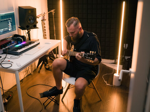 Musician Plays Guitar in Home Studio With Digital Setup
