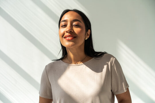 Confident Brunette Woman Smiling in Natural Sunlight Space