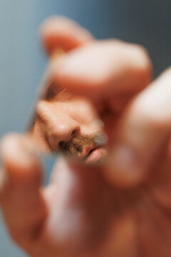 Man Looking at Himself in a Small Mirror, Close-Up Shot