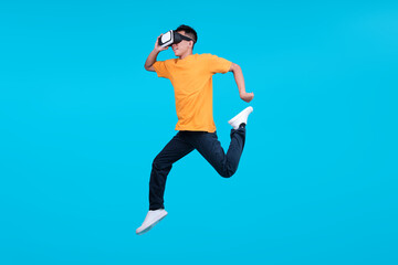 Fototapeta premium Full Length of Energetic Young Man Jumping High Wearing VR Headset
