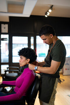 Hair stylist works on client in salon setting