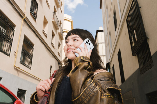 Casual street scene with young person talking on phone in spring