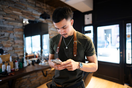 Barber using a phone in a barbershop