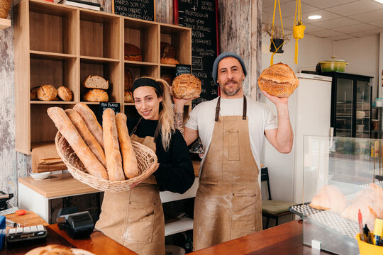 Bakery Workers Hold Bread and Baked Goods in a Shop