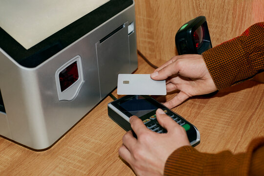 Person paying with card using POS terminal at counter