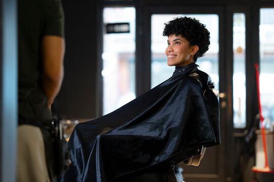 Woman smiles during haircut at salon in city