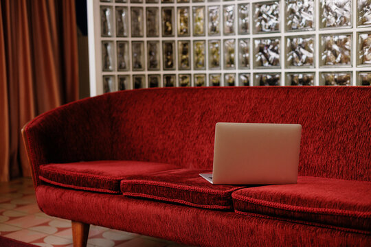 Laptop on red sofa in modern interior