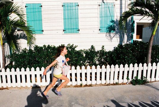Happy child runs down street in Hope Town, Elbow Cay, Bahamas