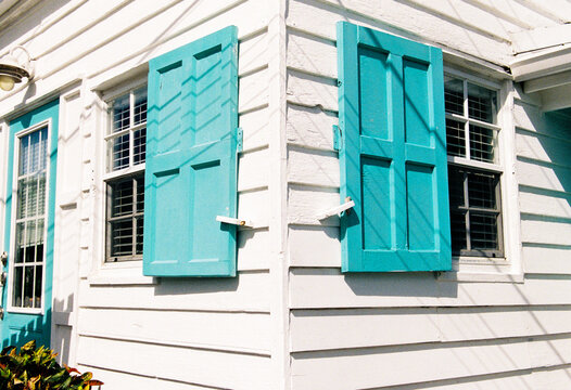 White house with colorful turquoise shutters in Hope Town, Bahamas