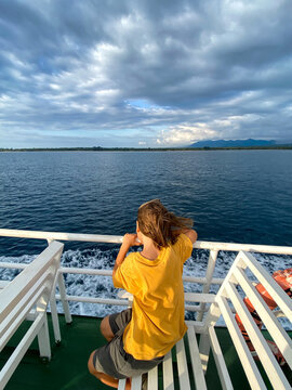 Child on ferry looking at ocean during sea crossing