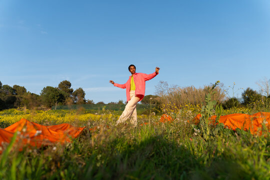 Dancer Performs in a Field With Bright Flowers in the Afternoon Sun