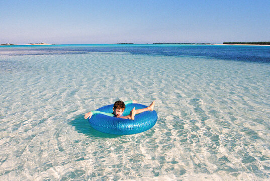 Funny film portrait of vacationing child in inner tube floatie 
