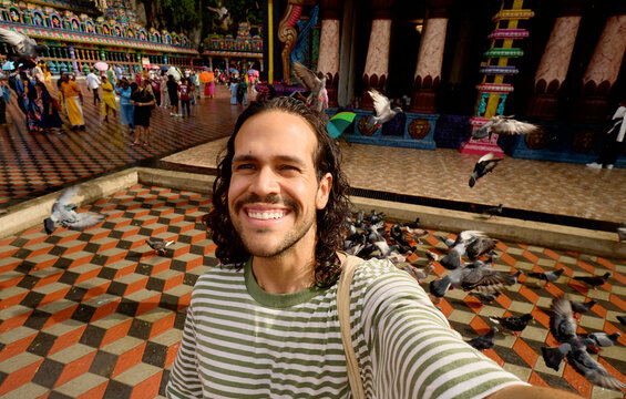 Man taking selfie with pigeons at Batu Caves Malaysia