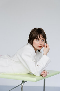  Pixie Cut Fashion Portrait Woman Lying with Hands on Table