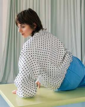 Fashion Portrait Polka Dot Blouse Blue Skirt Half-Turn on Table


