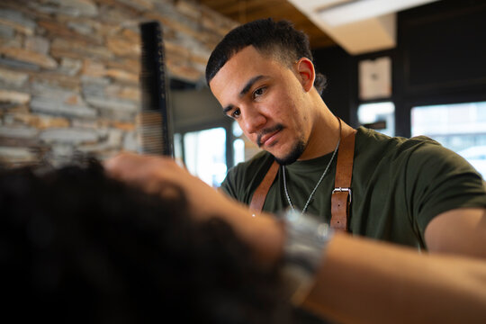 Hair stylist works on curly hair in salon