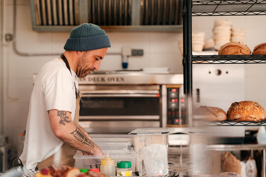 Baker Prepares Dough in a Busy Bakery Kitchen 